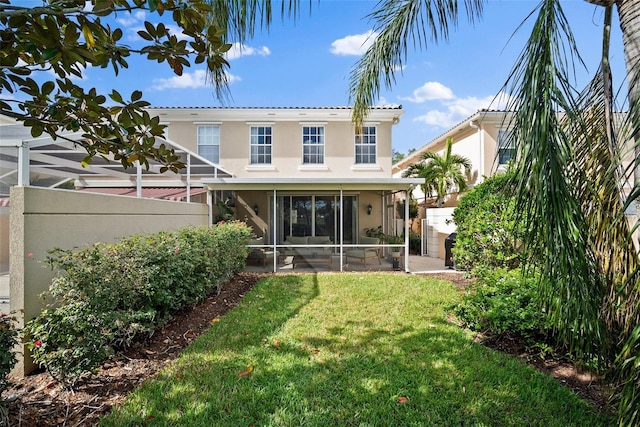 rear view of property with a sunroom and a yard