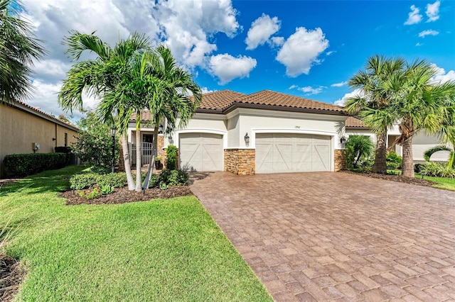 mediterranean / spanish home featuring a garage and a front lawn