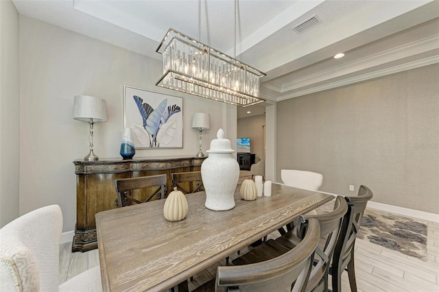 dining area featuring ornamental molding, light hardwood / wood-style floors, and a tray ceiling