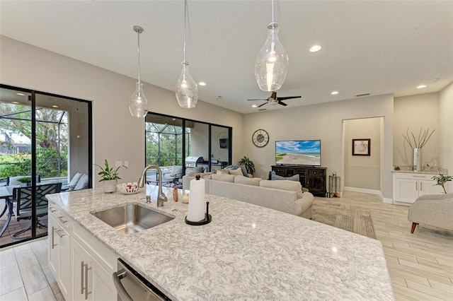 kitchen featuring light wood-type flooring, white cabinets, sink, and plenty of natural light