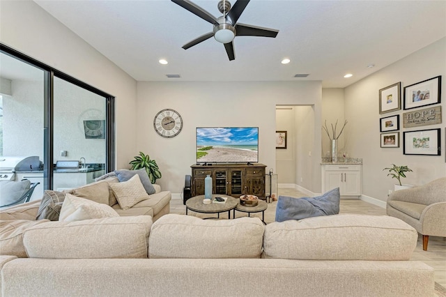 living room with light wood-type flooring and ceiling fan