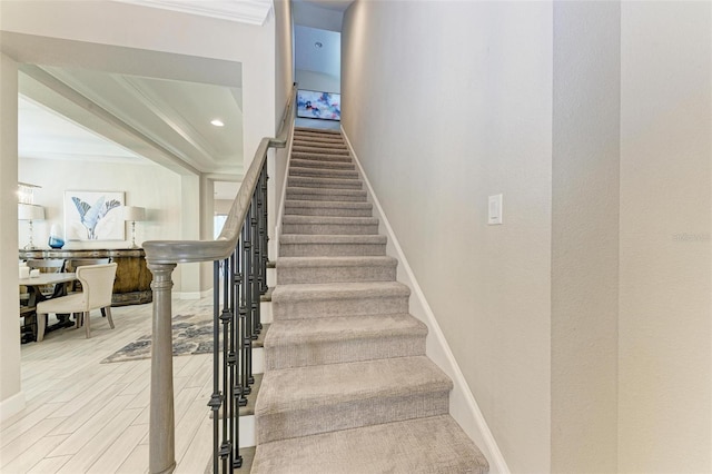 stairs with hardwood / wood-style flooring and ornamental molding