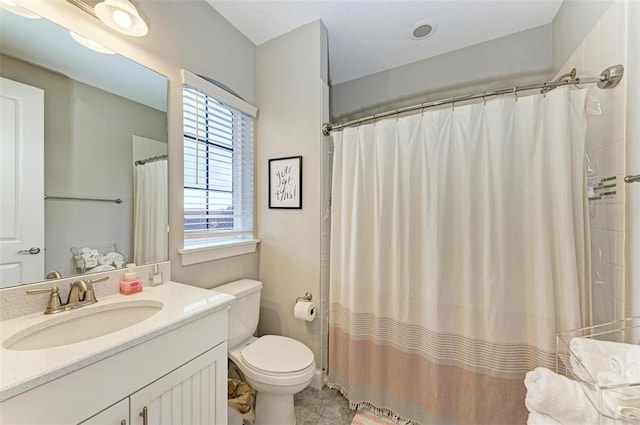 bathroom featuring toilet, vanity, tile patterned flooring, and walk in shower