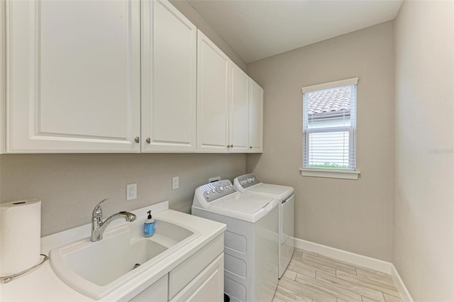 washroom with cabinets, separate washer and dryer, sink, and light hardwood / wood-style flooring