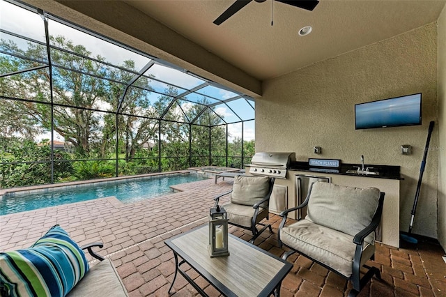 view of swimming pool featuring an outdoor kitchen, ceiling fan, a patio, a lanai, and area for grilling