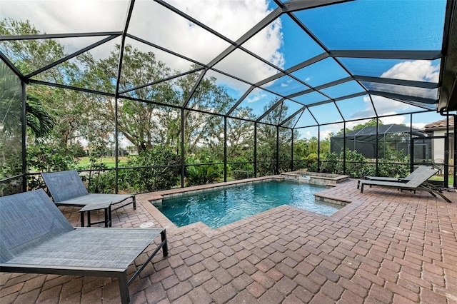 view of swimming pool featuring glass enclosure, a patio, and an in ground hot tub