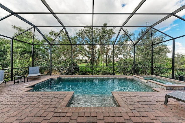 view of pool featuring a patio area, a lanai, and an in ground hot tub