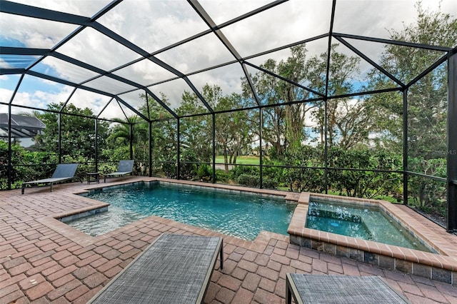 view of pool with a patio, a lanai, and an in ground hot tub