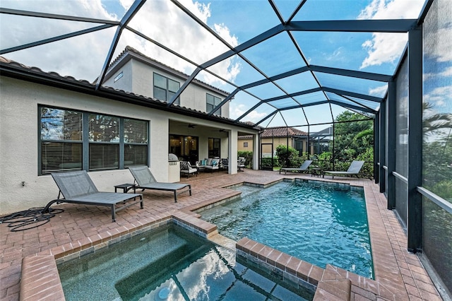 view of swimming pool with an in ground hot tub, a patio, outdoor lounge area, a lanai, and ceiling fan