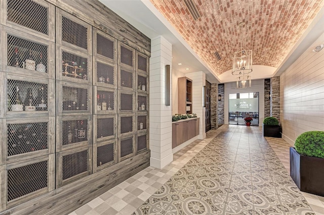 hall with a chandelier and brick ceiling