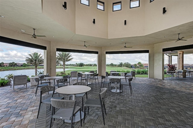 view of patio / terrace featuring a water view and ceiling fan