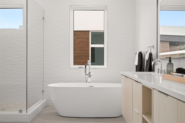 bathroom with vanity, tile patterned floors, plus walk in shower, and tile walls