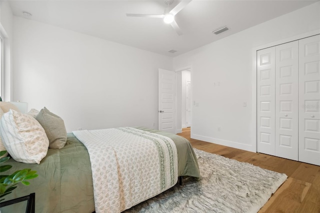 bedroom with hardwood / wood-style floors, ceiling fan, and a closet