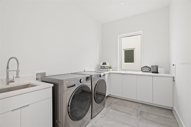 washroom with cabinets, sink, and washer and dryer