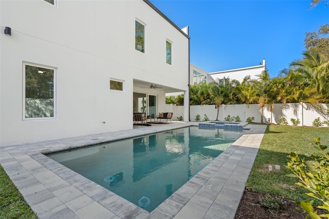 view of swimming pool with a patio area, a lawn, and ceiling fan