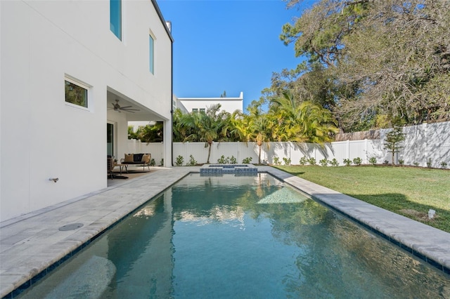 view of swimming pool featuring ceiling fan, a lawn, and a patio area