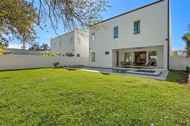 rear view of house with a lawn and a patio