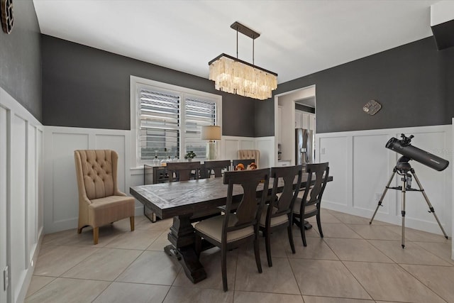 tiled dining room featuring a notable chandelier