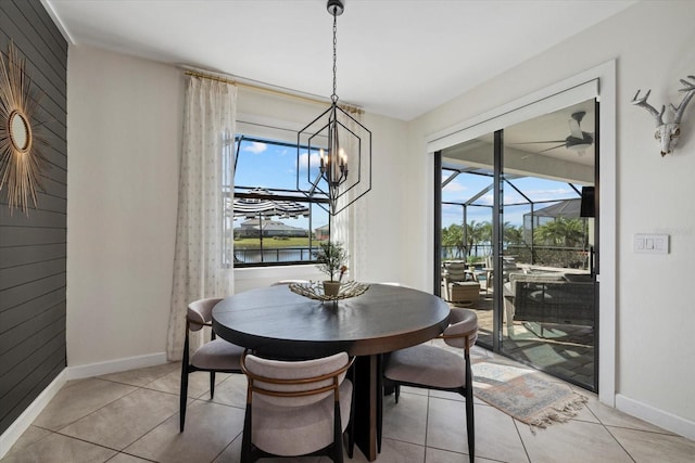 tiled dining room featuring a notable chandelier and a water view