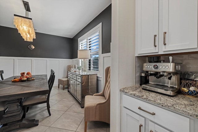 kitchen with decorative backsplash, decorative light fixtures, white cabinetry, and light tile patterned flooring