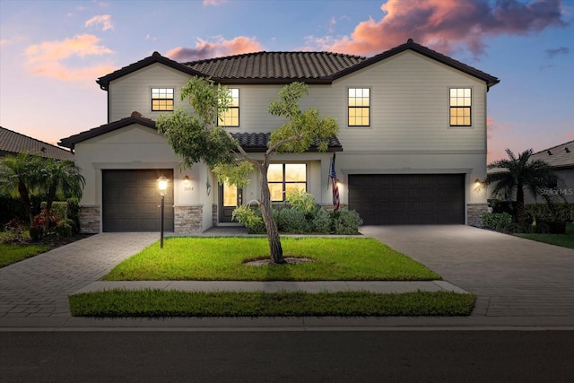 view of front of house featuring a garage and a lawn