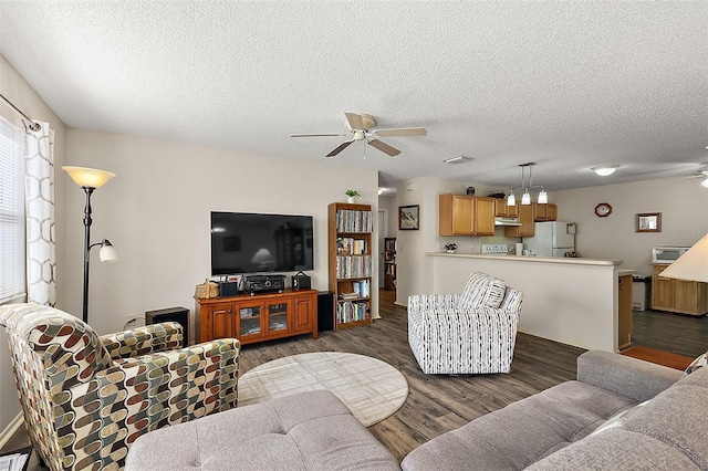 living room with ceiling fan, dark wood-type flooring, and a textured ceiling