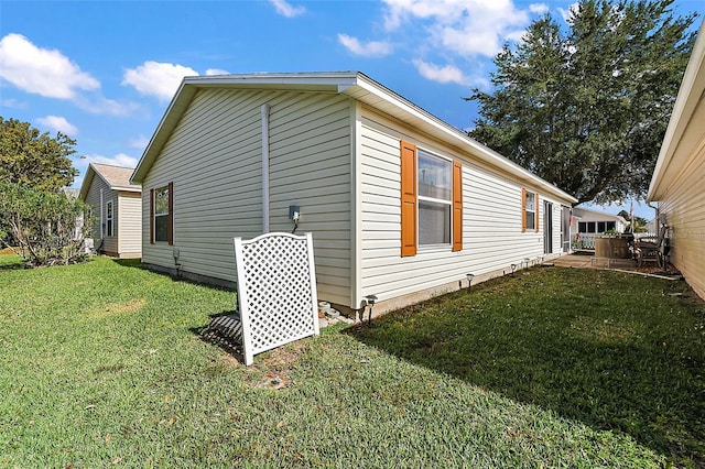 view of side of property featuring a yard and a patio area