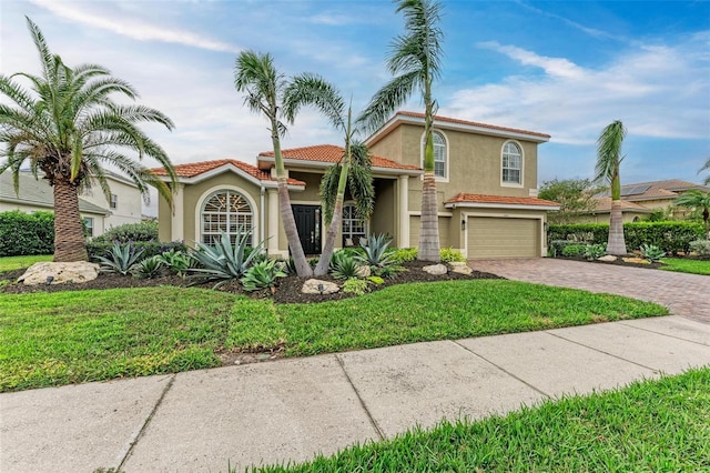 mediterranean / spanish-style home with a garage and a front lawn