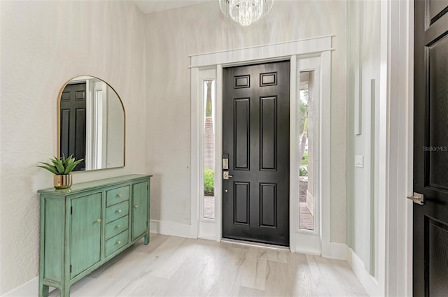 entrance foyer featuring light hardwood / wood-style floors and an inviting chandelier