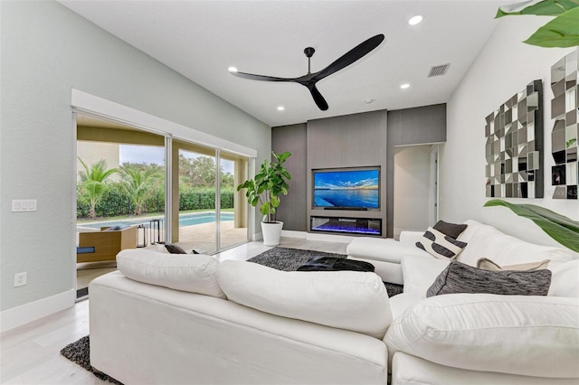 living room featuring ceiling fan and light hardwood / wood-style flooring