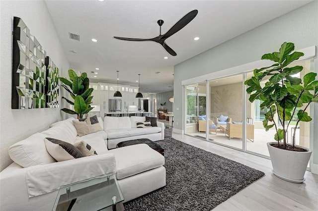 living room with ceiling fan and light hardwood / wood-style flooring