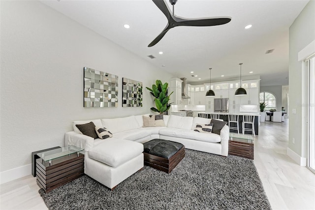 living room with light wood-type flooring and ceiling fan