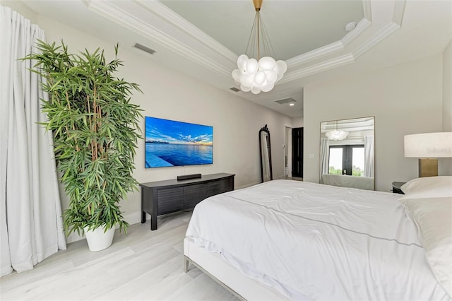 bedroom with french doors, ornamental molding, a raised ceiling, an inviting chandelier, and hardwood / wood-style floors