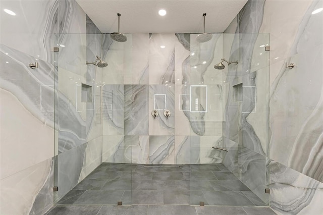 bathroom with a shower with door, a textured ceiling, and tile walls