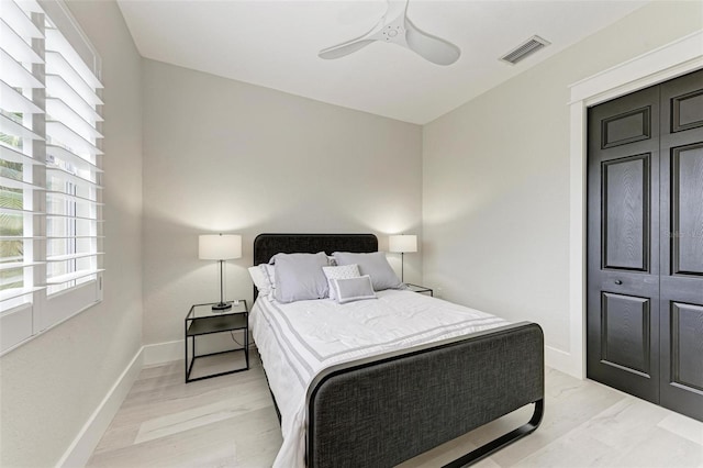 bedroom with ceiling fan, a closet, and light hardwood / wood-style flooring