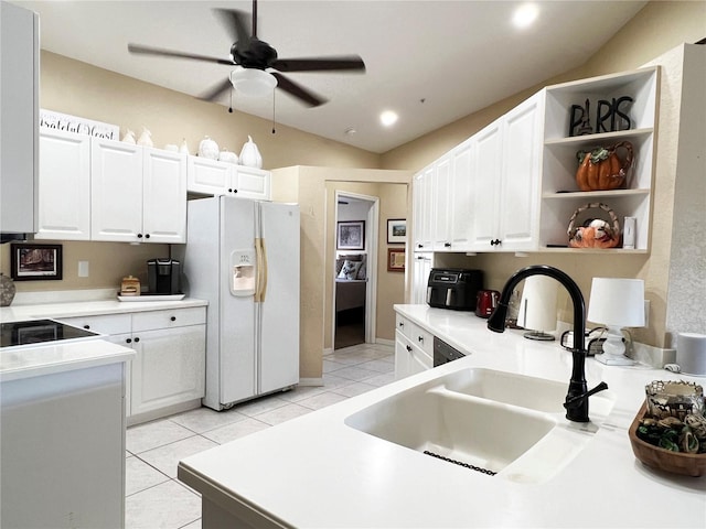 kitchen featuring sink, white cabinets, light tile patterned flooring, and white refrigerator with ice dispenser