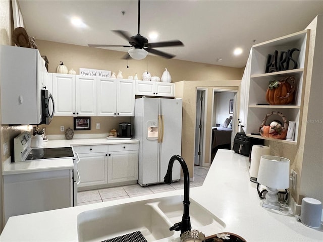 kitchen featuring stove, ceiling fan, sink, white cabinetry, and white fridge with ice dispenser