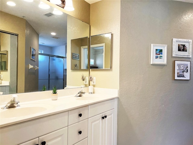 bathroom featuring vanity and a shower with shower door