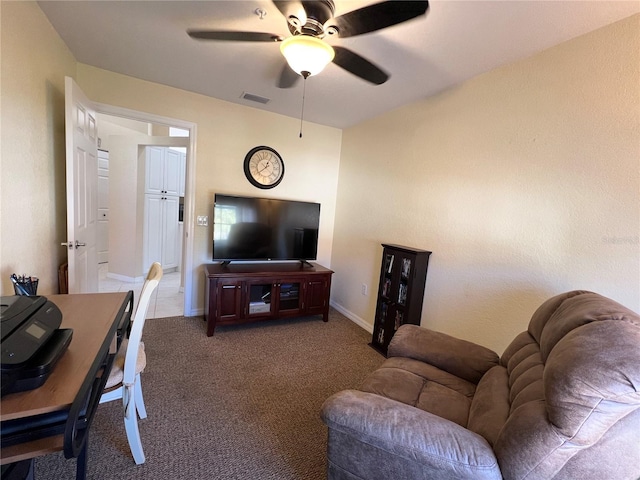 living room with ceiling fan and dark colored carpet