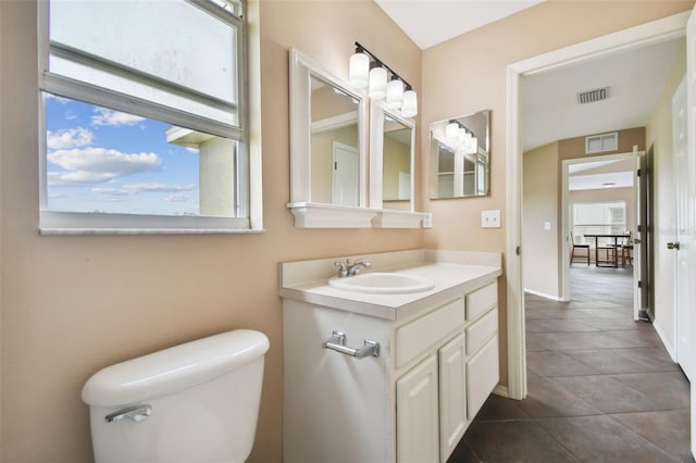 bathroom with tile patterned flooring, vanity, and toilet