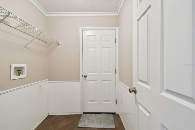 laundry area with ornamental molding, washer hookup, dark tile patterned floors, and a textured ceiling