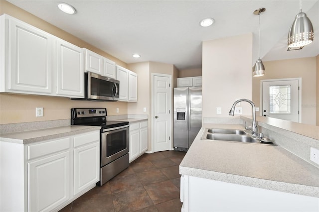 kitchen with white cabinets, appliances with stainless steel finishes, hanging light fixtures, and sink