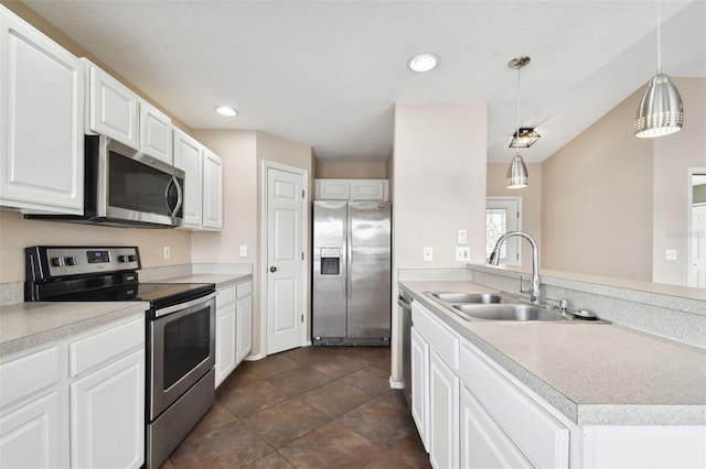 kitchen with white cabinetry, sink, pendant lighting, dark tile patterned flooring, and appliances with stainless steel finishes