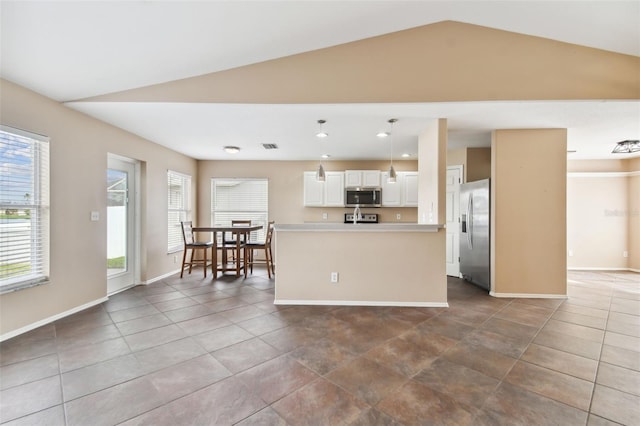 kitchen with white cabinetry, a kitchen island, vaulted ceiling, hanging light fixtures, and stainless steel appliances