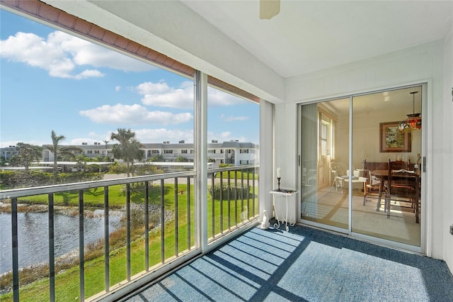 sunroom featuring plenty of natural light, a water view, and ceiling fan