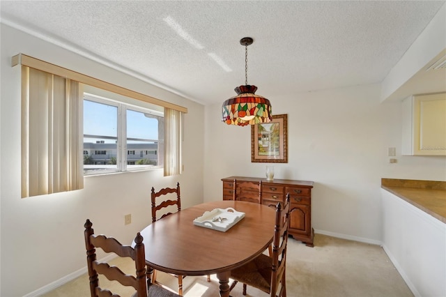 carpeted dining room with a textured ceiling