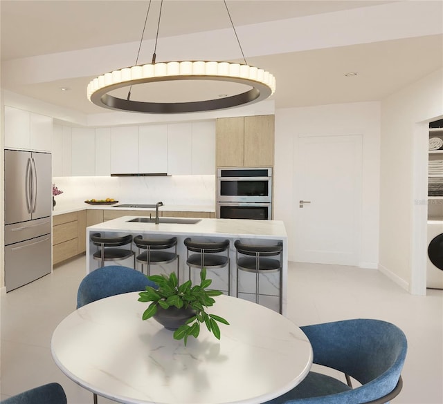 dining space featuring sink, washer / dryer, and light tile patterned flooring