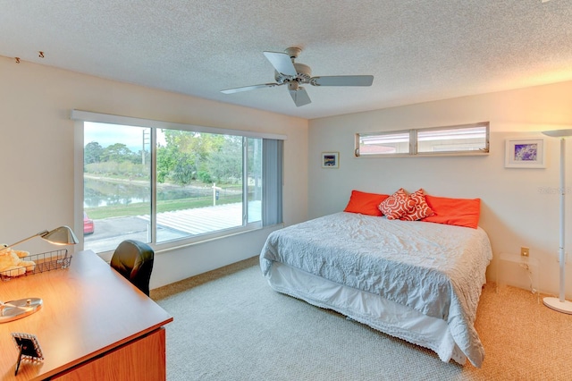 bedroom featuring ceiling fan, a textured ceiling, and light colored carpet