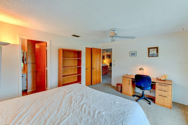 carpeted bedroom with ceiling fan and a textured ceiling