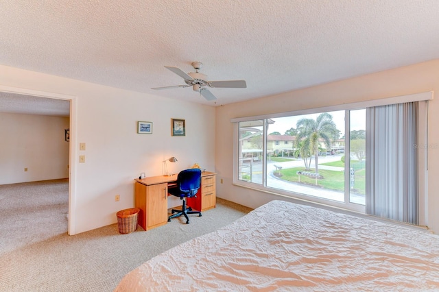 carpeted bedroom with a textured ceiling and ceiling fan